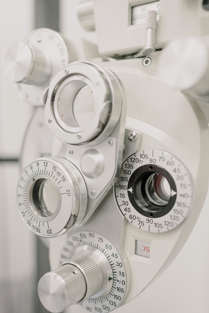 Fragment of white bifocal optometry eyesight measurement phoropter with different lenses and diopters placed in professional clinic on blurred background